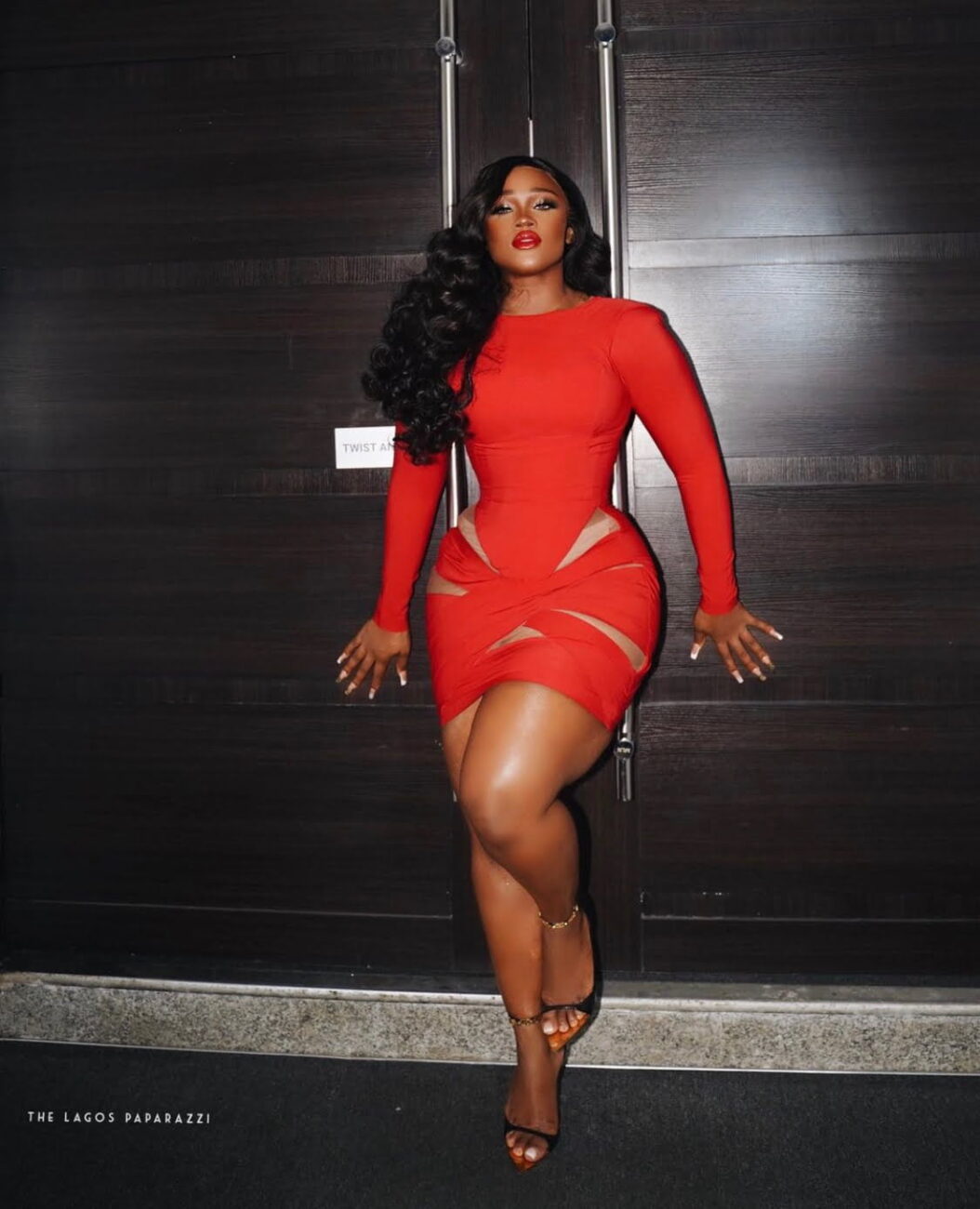 Ceec in a fitted red dress.