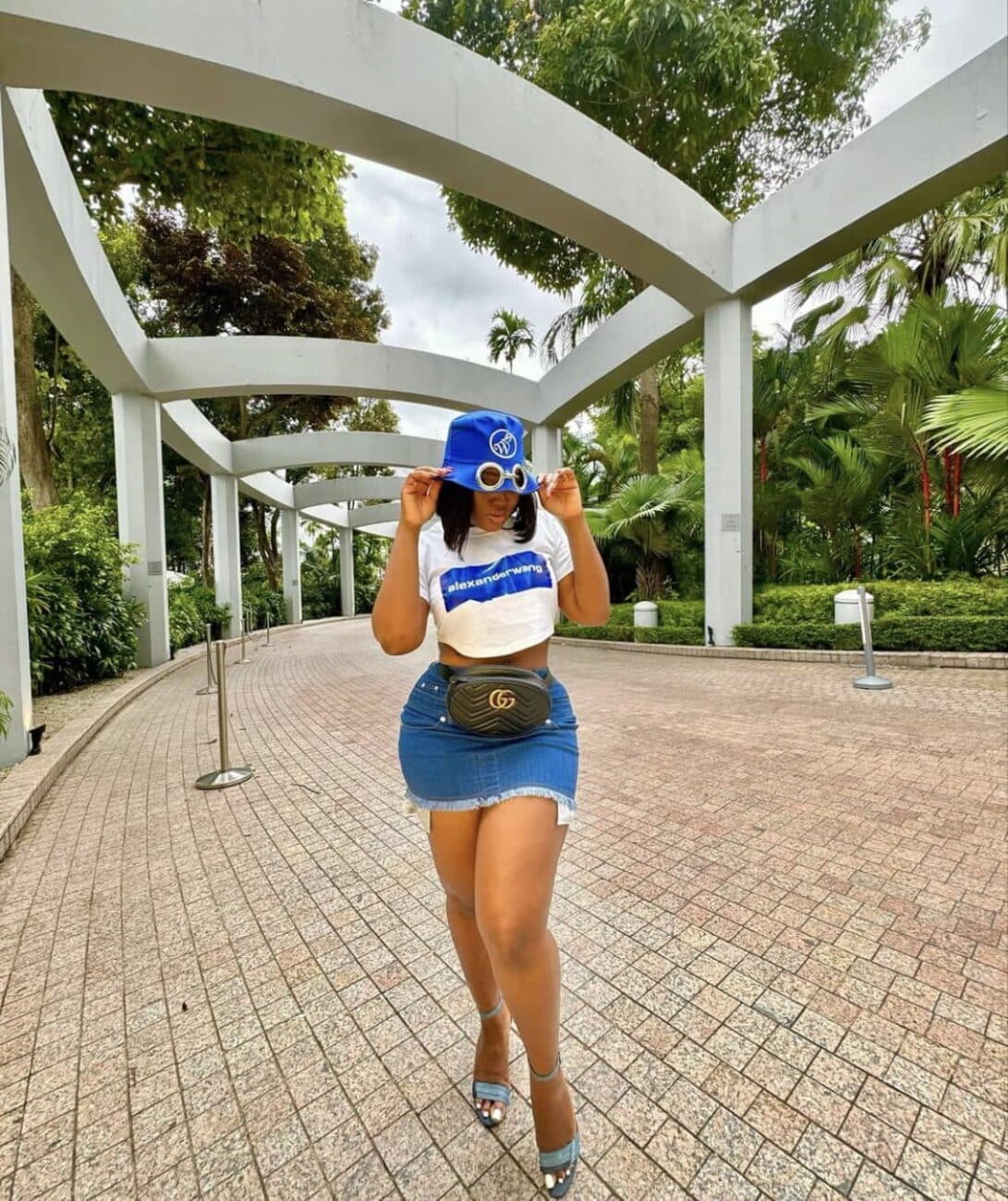 Ceec in a crop top and denim skirt.